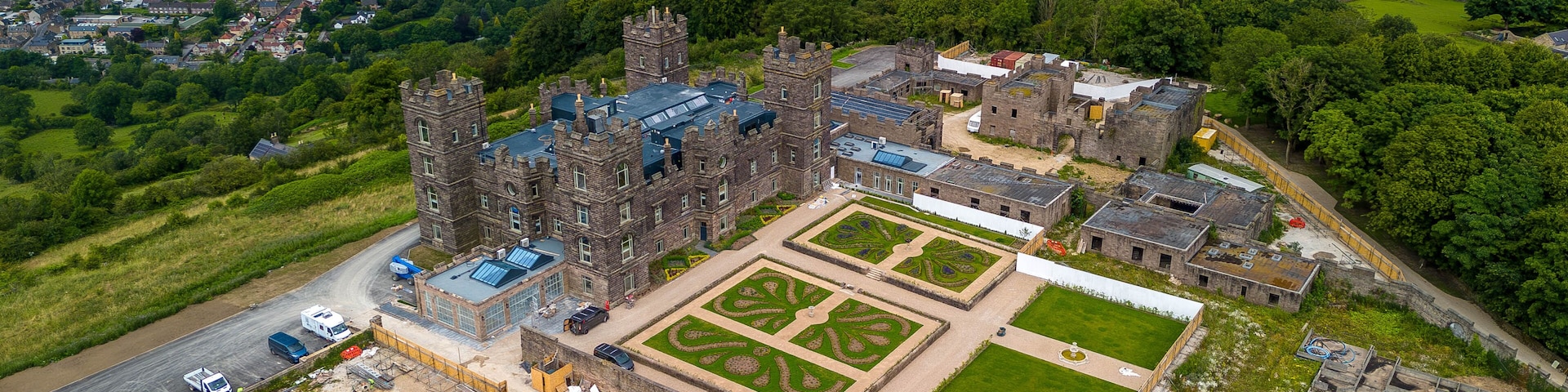 An aerial view of a historic castle with a large courtyard and surrounding landscape.