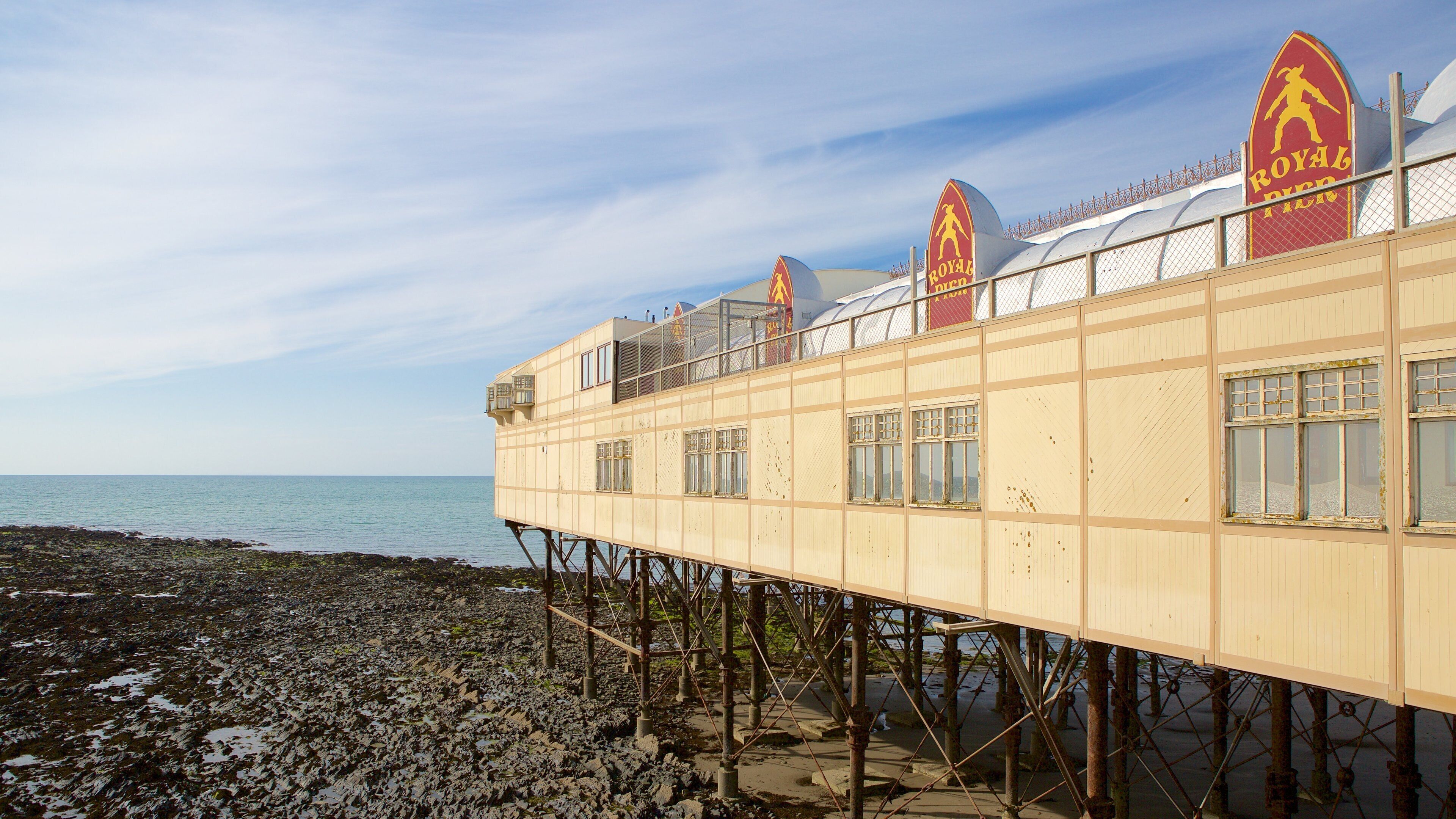 A pier with a restaurant named "Royal Pier" extending over a rocky shoreline.