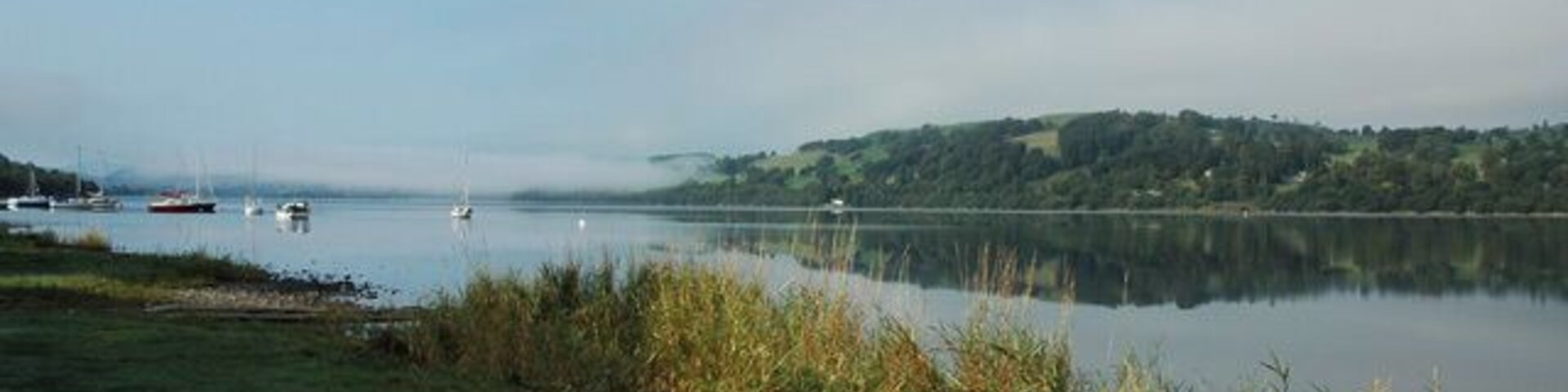 The cruising fleet on their moorings, Llyn Tegid. A distant view of the 'White House' and the morning mist rising above the Bala Sailing Club, Cruiser Fleet, moored on Llyn Tegid..