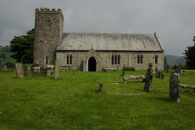 A stone church with a tower and a graveyard.