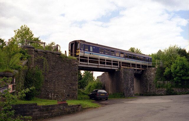 Railway Bridge, Builth Road, near to Builth Road, Powys, Great Britain. A "Heart of Wales" line train crosses a bridge over the route of the Mid-Wales Railway.