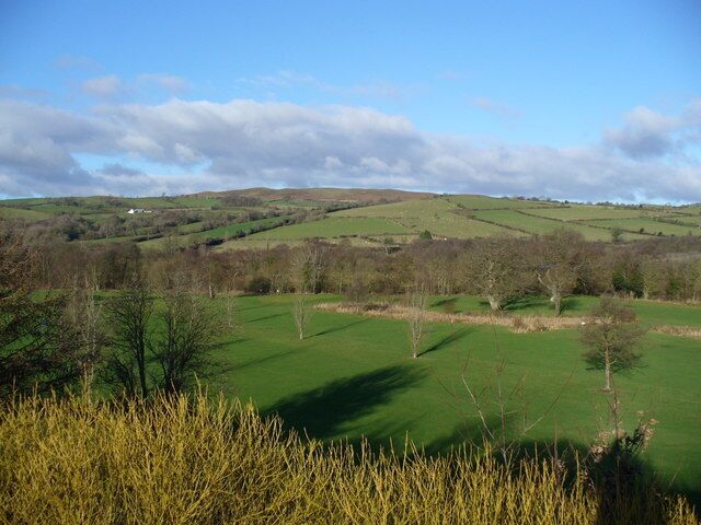Rolling green hills, a clear sky, and a grassy field.