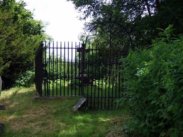 Grave of John Colby One of several railed-off grave sites at Manordeifi: just as local gentry enjoyed their private box pews in church so their preference for separation from the commoners persisted after death. Here lies John Colby of Ffynone (1816-1874) with some very ornate wrought iron work surmounting his enclosure.
