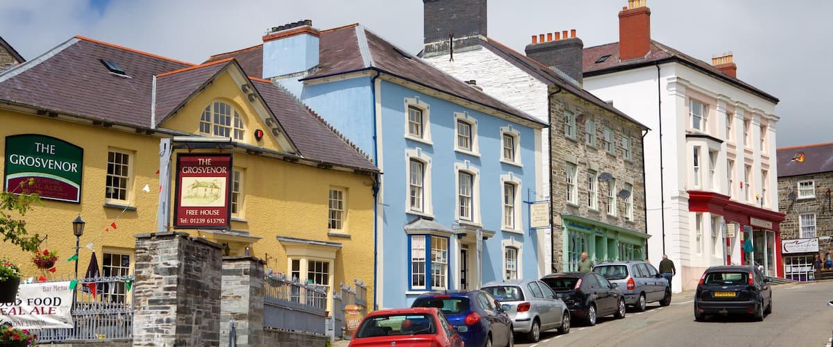 A street lined with colorful buildings, including 'The Grosvenor' pub and 'Café & Coffee Bar'.