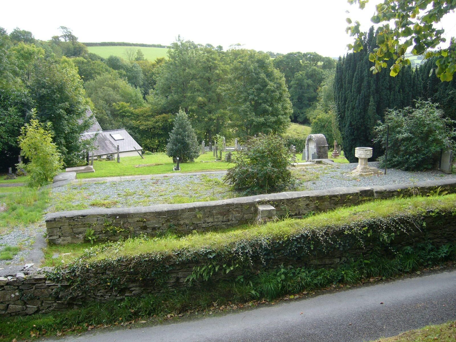 Foundations of the church of St. Tygwydd, Llandygwydd, Ceredigion, Wales. Clearly the church built in 1857 stood here. The font is in the position marked on this ground plan. Indeed the boot scrapers are still in position by the steps up to the porch. But the church has completely disappeared. The only clue I have so far found is its mention in this list of listed buildings demolished in 1999. A smaller building nearby is now used as the church.