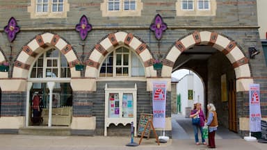 A historic building with arched windows and a signboard advertising a market.
