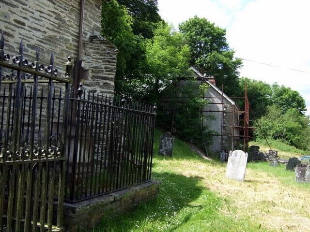 Manordeifi old church, bard's gave and old stable Looking west from the south side of the church the Celtic cross within the railed enclosure, left, marks the grave of John Blackwell (1797-1840) who took the bardic name Alun. Straight ahead, just outside the gate, is a building that once provided stabling for horses belonging to members of the congregation who rode or drove to church. It has been converted into a private house.