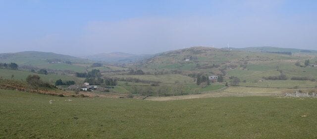 Panorama of Hiraethog hills The farms are Nant-y-Pyd to the left and Hendre Garthmeilio centre right. There is a windfarm on the horizon.