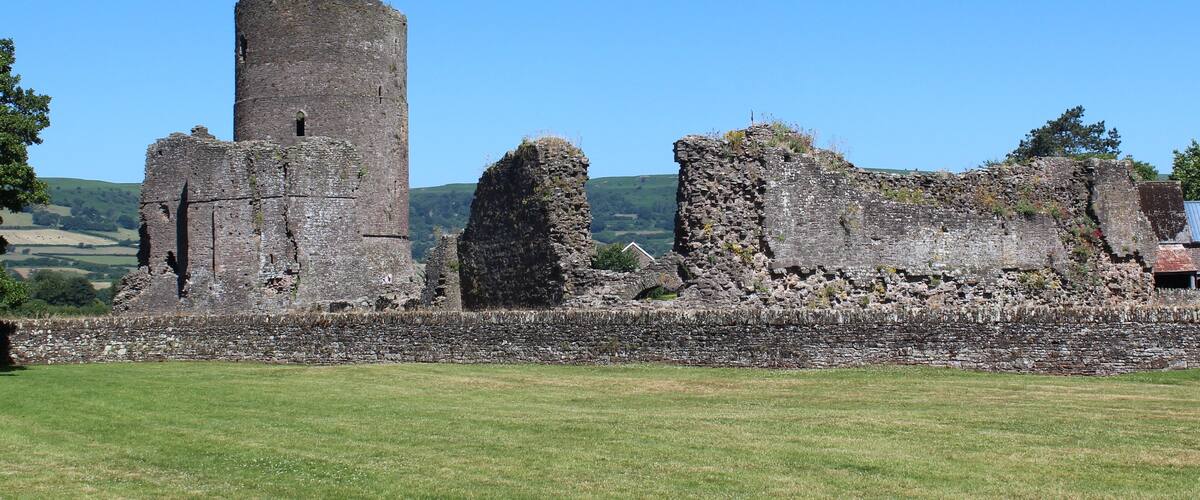 A medieval castle ruin with a tall tower and several other structures.
