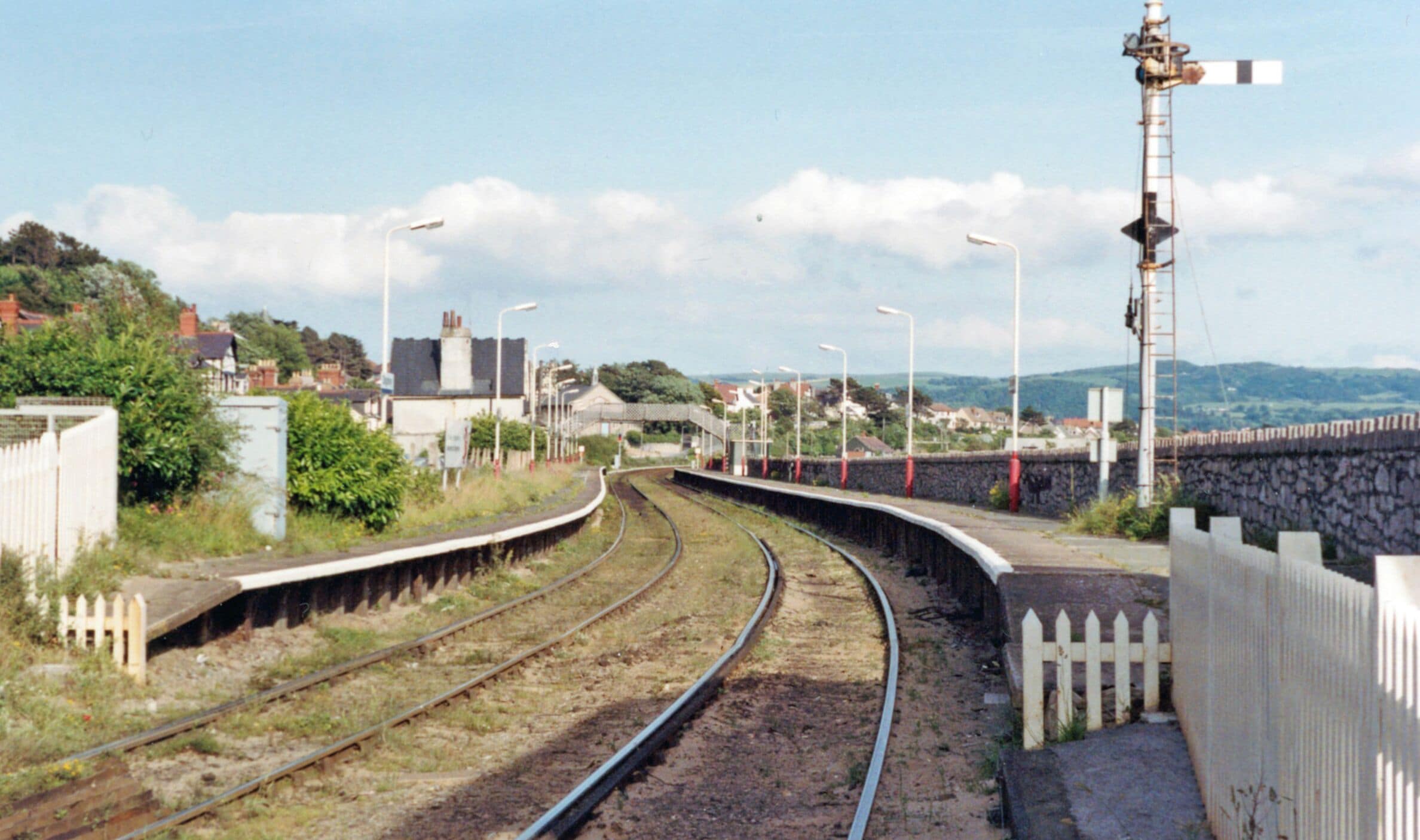 Deganwy station, 1992. View SE, towards Llandudno Junction: ex-LNWR Llandudno branch. This is the one intermediate station on this short branch; it has remained open - but look at the weeds! (Cf. SH7779 : Deganwy Station). The Conwy Estuary is ahead and in the distance is Mynydd Llanelian (1,036 ft.) and other hills of the Conwy County east of the Vale of Conwy.