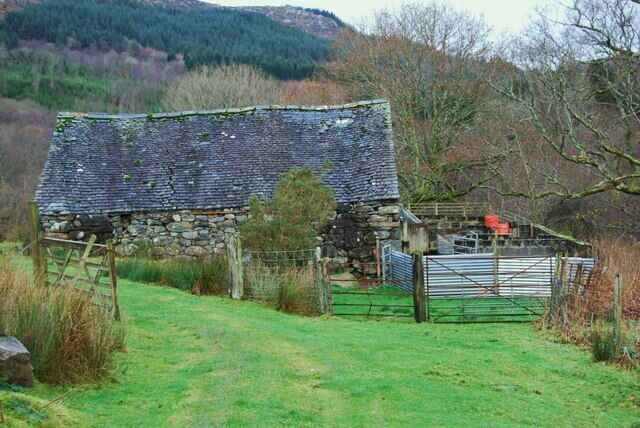Small barn and sheep handling pens A small barn and handling pens that are well maintained. The barn looks as if it is used as a store for farm supplies and animal fodder.