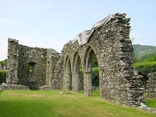 A stone ruin with arches and a grassy foreground.