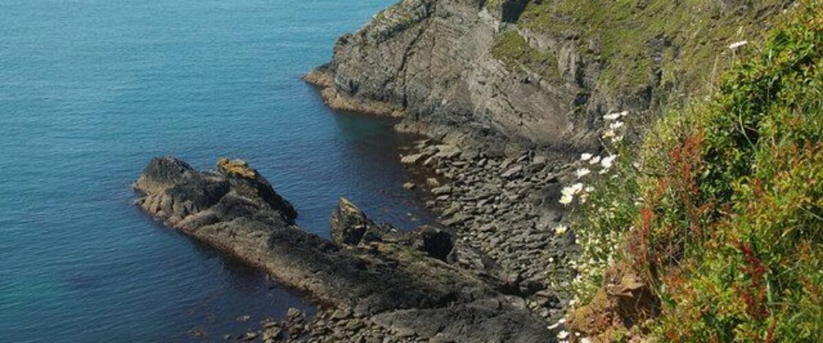 A rocky coastline with cliffs and a calm sea.