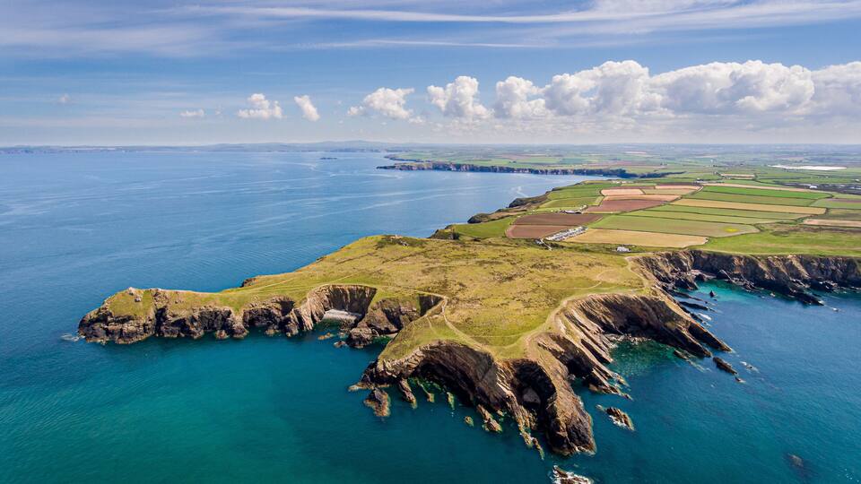 A coastal landscape with cliffs and farmland.