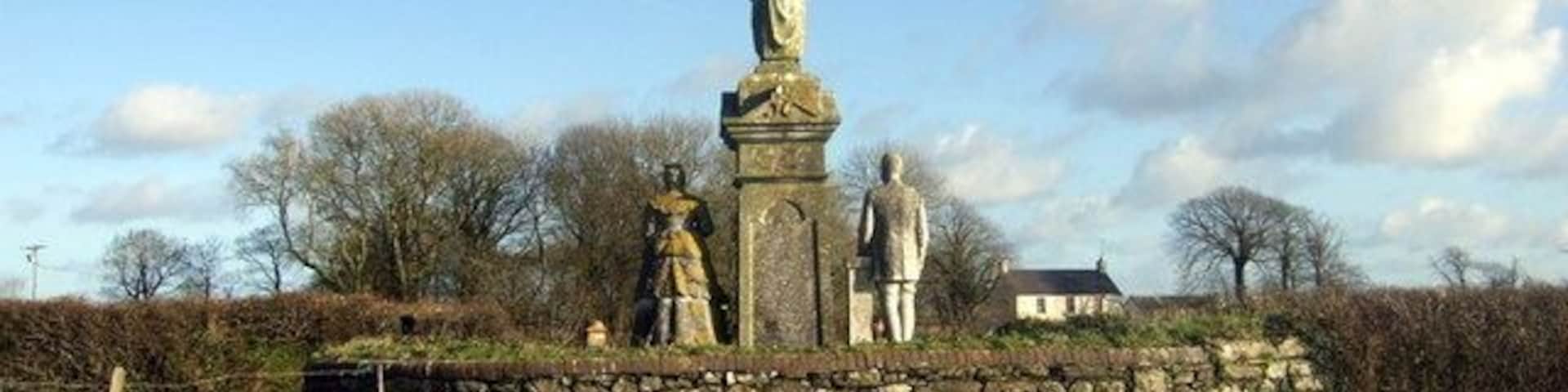 Scollock West memorial (3). From behind, looking east, the farmer and his wife are seen to face the house and buildings - and the rising sun, a old tradition. Next image 622951