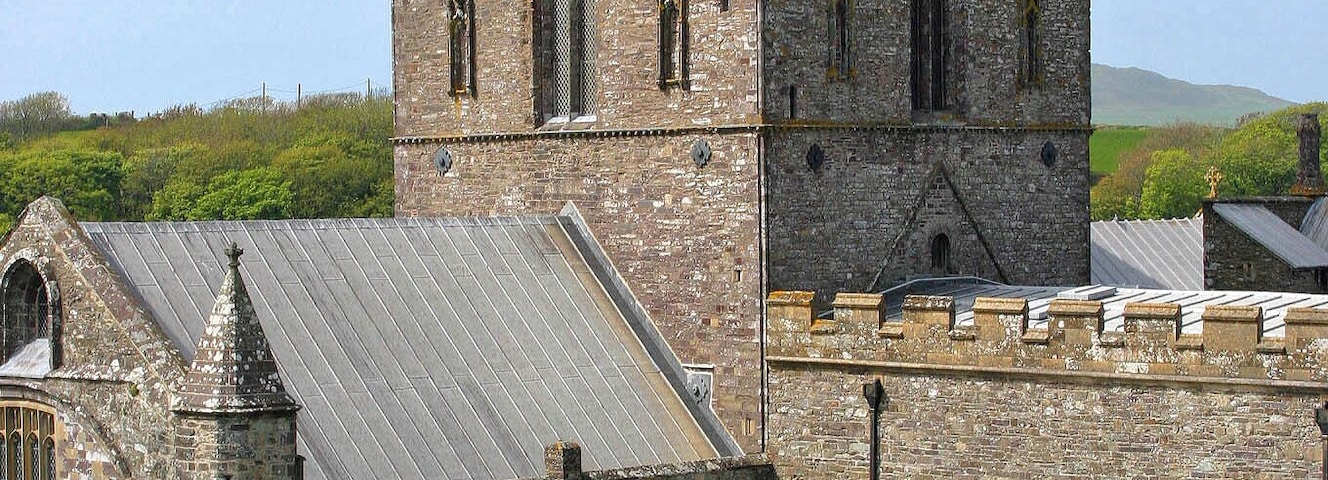 Una iglesia histórica con una torre alta y ventanas de arco.
