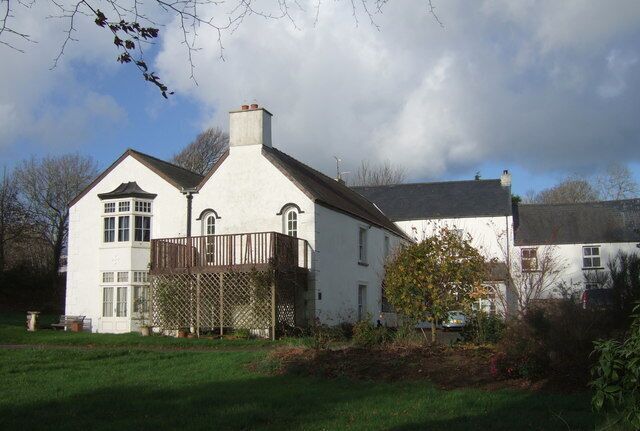 A white house with a wooden deck and a garden.