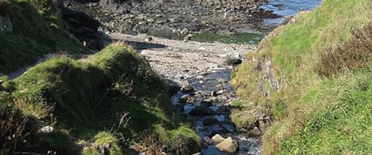 Stream reaches the sea, Aber Draw. Water from the stream would have been diverted via a leat to the nearby Trefin Mill in the days when it was used for grinding wheat and barley. See also 1518296 Viewed from the footbridge over the valley on the coast path. Note the 'stone circle' top left. 1519624