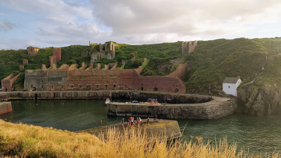 Porthgain harbour showing remains of industrial stone, slate and brick works and the hoppers used to store crushed stone before shipment.
