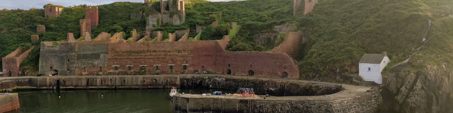 Porthgain harbour showing remains of industrial stone, slate and brick works and the hoppers used to store crushed stone before shipment.