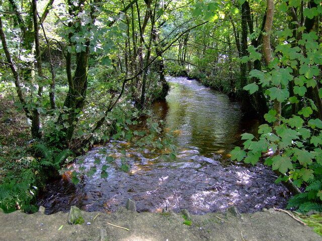 Afon Anghof River seen flowing towards the footbridge a short distance away from the road bridge.