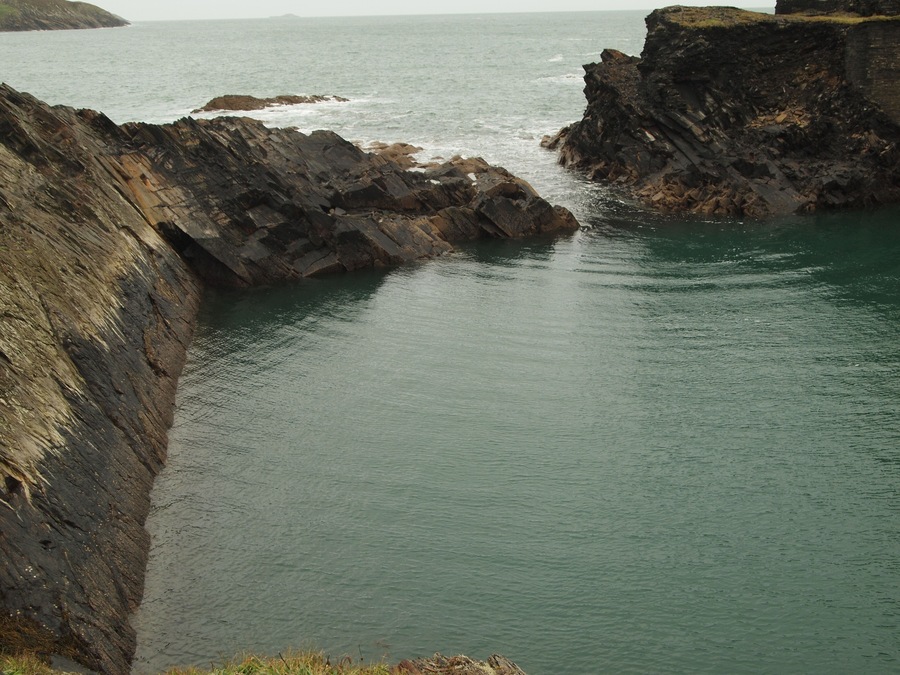 The Blue Lagoon, Abereiddy, Pembrokeshire, Wales. A disused coastal slate quarry with a narrow entrance to the sea. Single-slit wave diffraction and reflection patterns can be seen on the water in the lagoon.