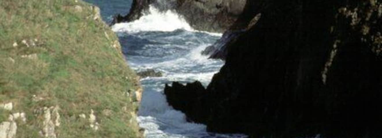 Abercastle, looking towards Pwllcrochan Looking through the channel between Ynys y Castell and the harbour inlet at Abercastle past the headland of Trwyn Llwynog to the remote beach at Pwllcrochan below St Nicholas. This shows the rugged nature of the Pembrokeshire coast in this area.