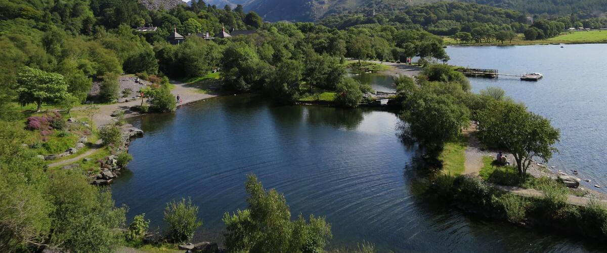 Un lago tranquilo rodeado de exuberante vegetación y montañas.