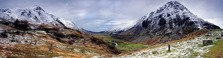 A mountainous landscape with a valley, a road, and a bridge.