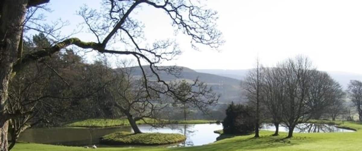 Ornamental Lake and View at Bodidris Hall Hotel Looking across the ornamental lake at Bodidris from the Clwydian Way. As it is just in front of the hall the wall looks as though it might be the remains of a 'Ha-ha'. Moel Garregog is in the distance.