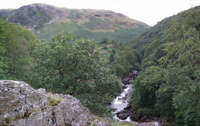 Afon Tywi and Craig Clungwyn Afon Tywi (Towy River) tumbles over the rocks to join Afon Pysgotwr Fawr. The hill on the left is Craig Clungwyn. To the right is Dinas Hill, once the hideout of the Welsh Robin Hood, Twm Sion Catti. His cave, high up on the tree covered slopes, is still a tourist attraction.