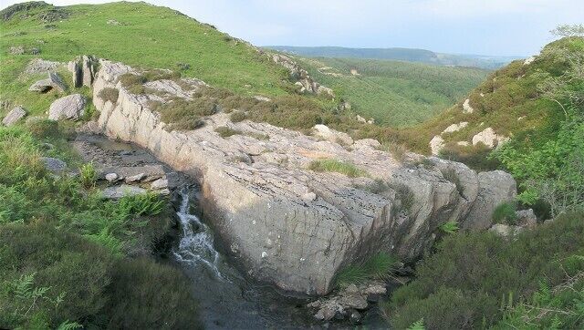 A rocky gorge with a small waterfall.