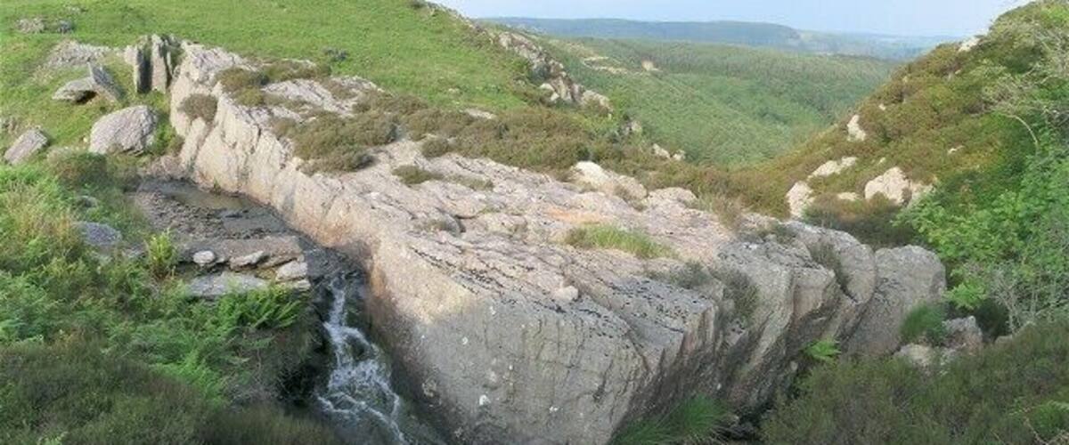 A rocky gorge with a small waterfall.