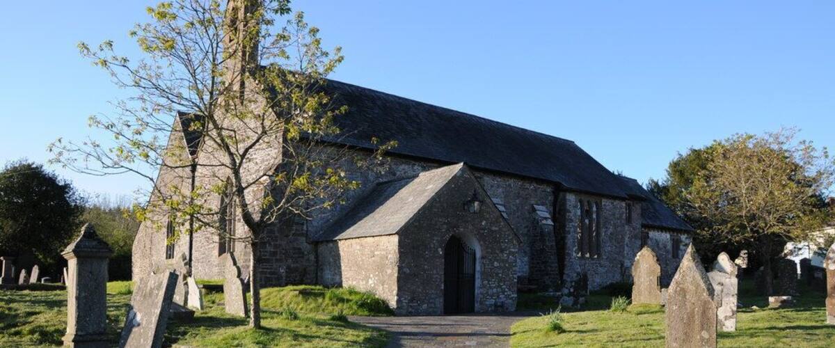 A stone church with a pointed roof and a pathway leading to it.