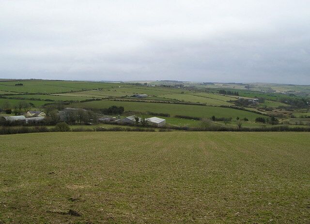 View over Farmland This is a typical upland view in Ceredigion with scattered farmsteads, clumps of trees, and grass fields surrounded by neatly trimmed hedges. It is mainly sheep country.