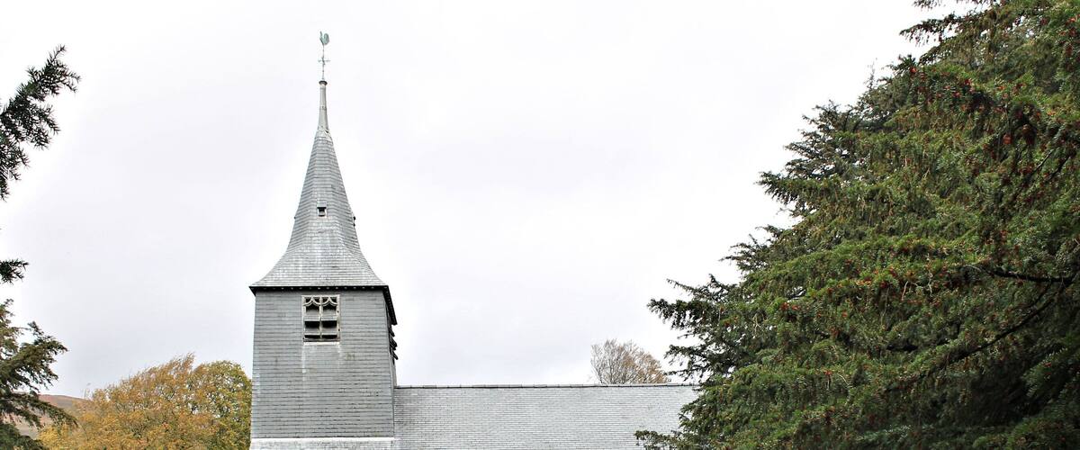 Une église dotée d’un clocher imposant et d’un cimetière situé devant.