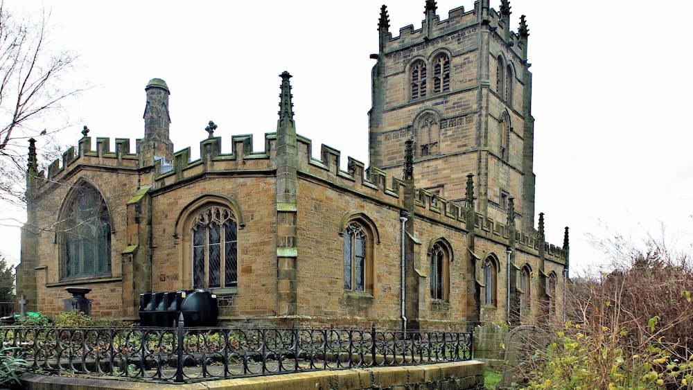 A historic stone building with arched windows and a tall tower.