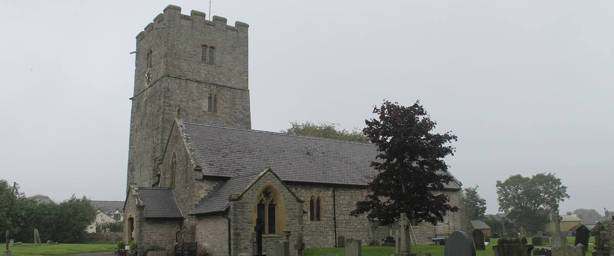 A church with a tall tower and a graveyard.