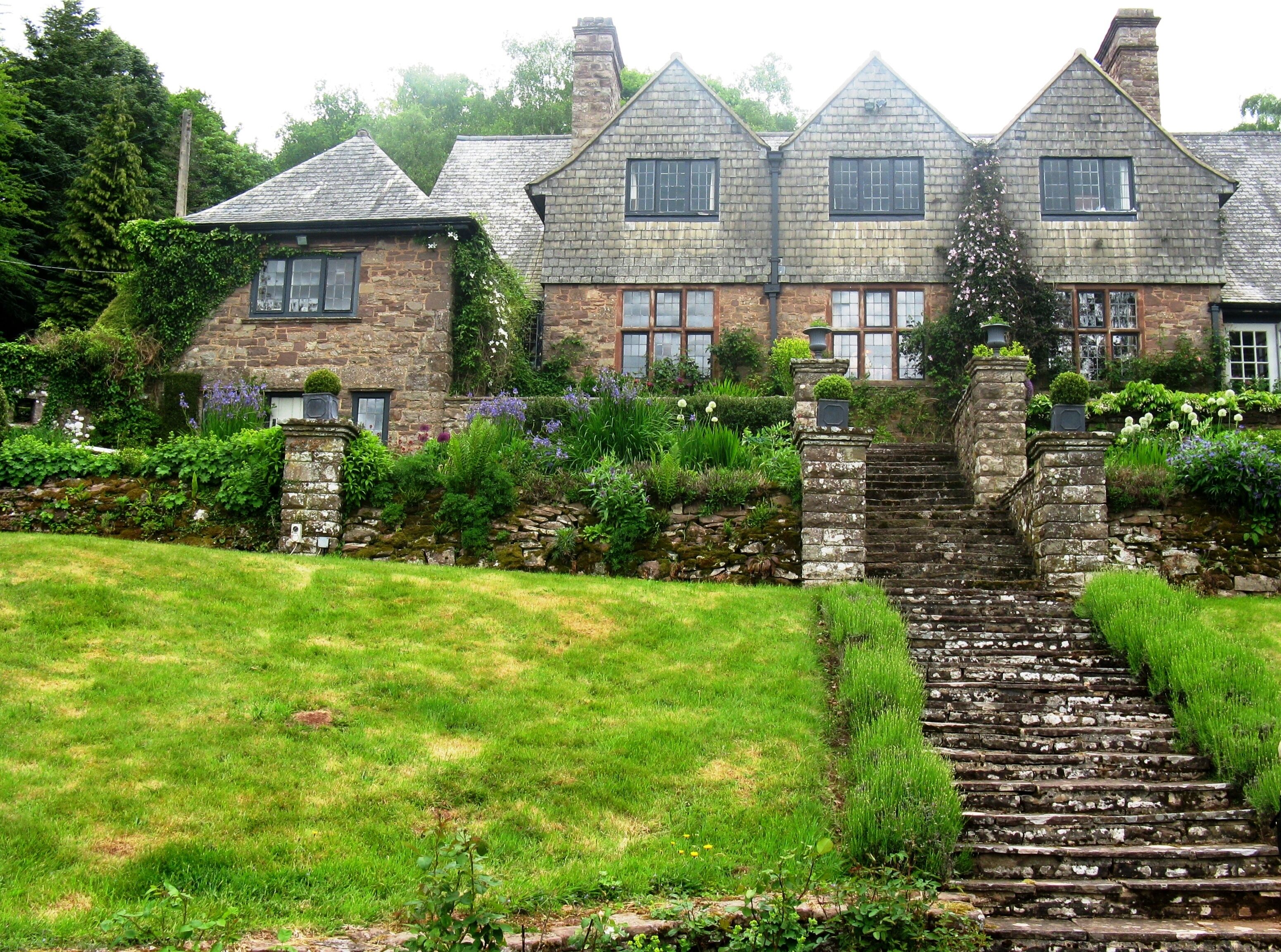 A stone house with a stone staircase leading to the entrance.