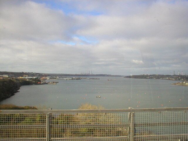 Milford Haven. A view taken looking west from the toll bridge across the Haven. The oil refineries and jetties can be seen in the background