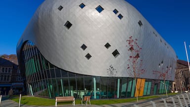 Un bâtiment moderne de forme sphérique, doté d’une surface réfléchissante et de nombreuses fenêtres.