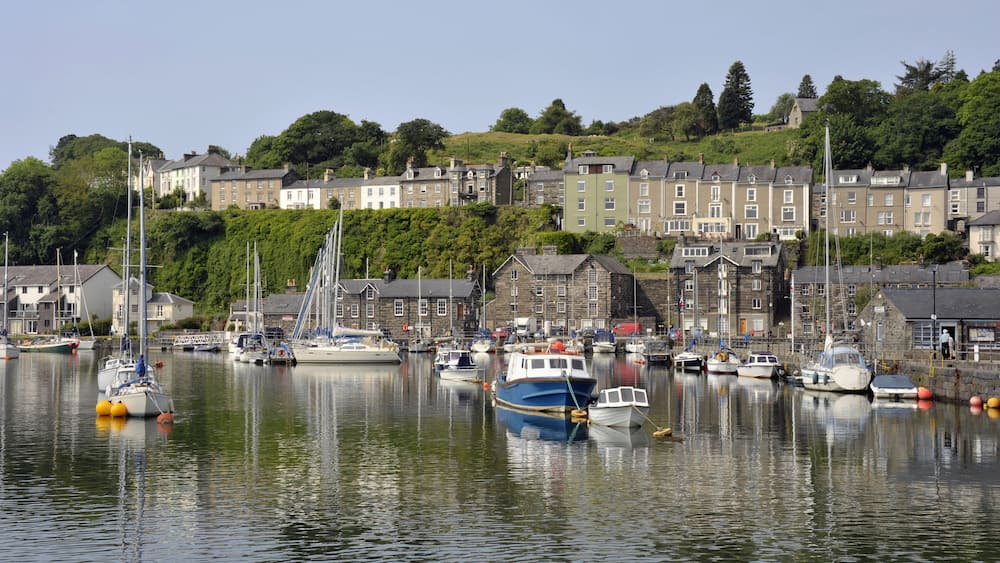 Porthmadog harbour with moored boats and overlooking houses in Wales. UK.; Shutterstock ID 574360264; purchase_order: SP-1332 HA Batch 2 August 2018; Order: ; client: HomeAway; other: To be paid with