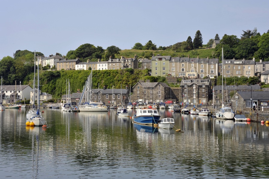 Porthmadog harbour with moored boats and overlooking houses in Wales. UK.; Shutterstock ID 574360264; purchase_order: SP-1332 HA Batch 2 August 2018; Order: ; client: HomeAway; other: To be paid with