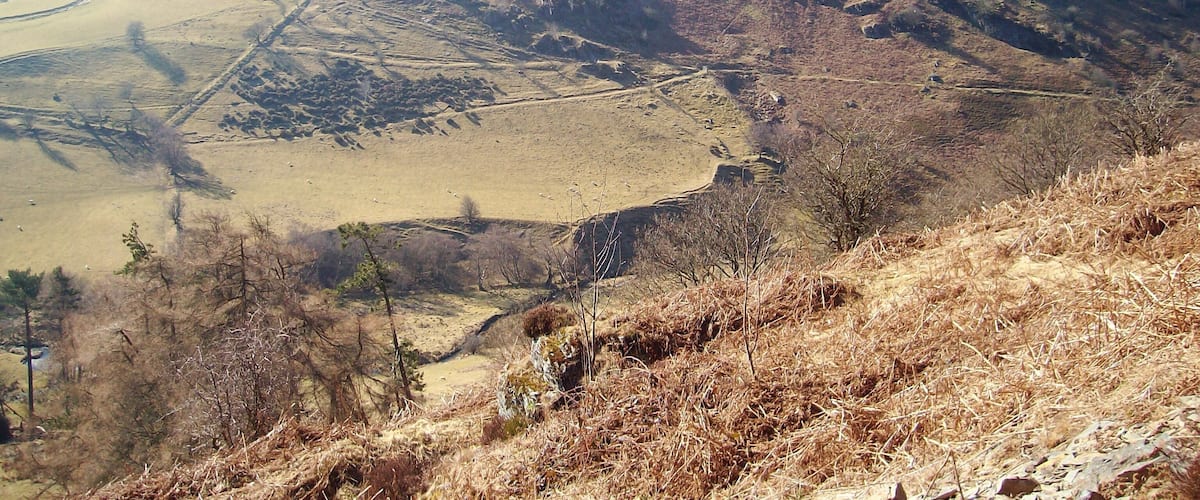 A mountainous landscape with a prominent peak, a valley, and a winding road.