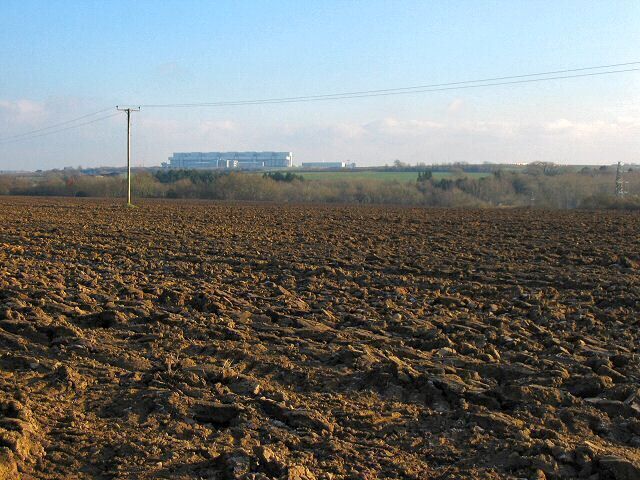 Vale of Glamorgan ploughed field. The Rhoose aircraft repair centre building is on the skyline.