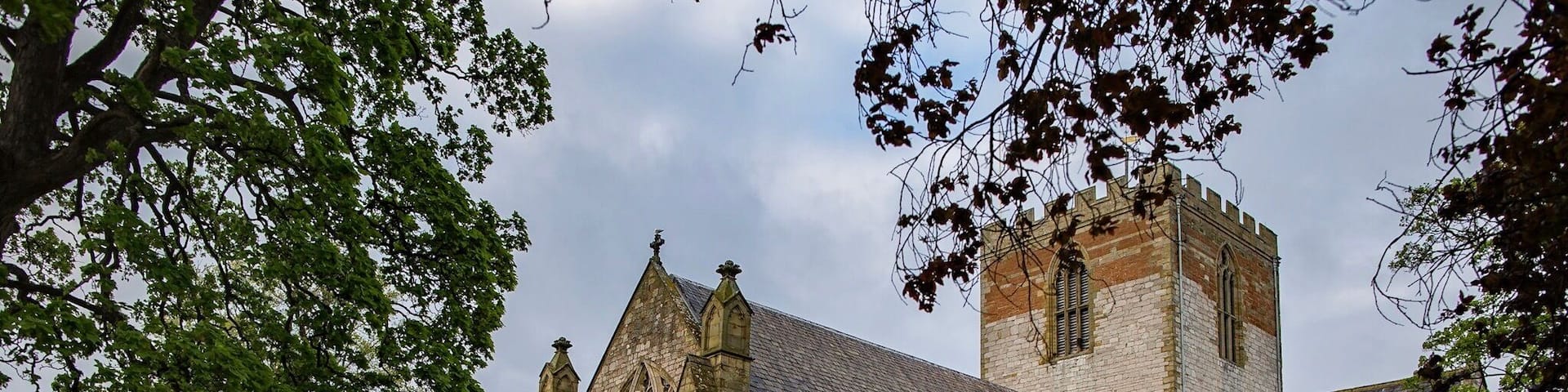 A historic church with a tall tower and a cemetery in front.