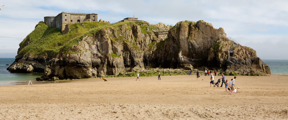 Tenby montrant cÎte escarpée, chùteau ou palais et plage