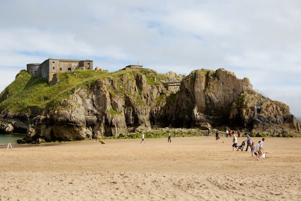 Tenby which includes château or palace, rocky coastline and a sandy beach