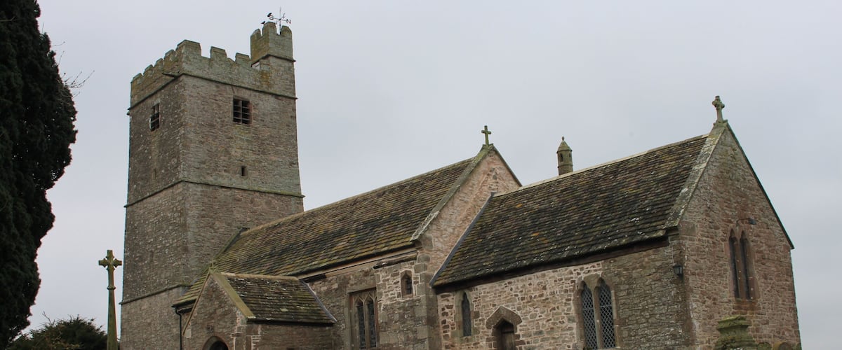 A historic church with a tall tower and a graveyard.