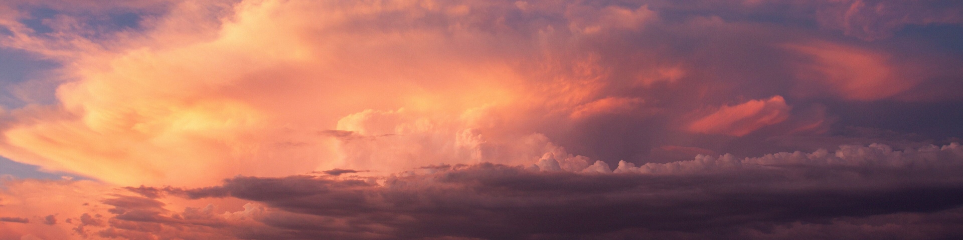 Paisagem desértica com vegetação escassa e um céu de pôr do sol espetacular.